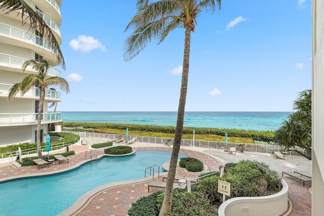 view of swimming pool with a patio area and a water view