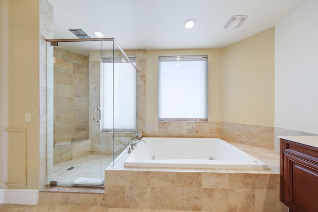 bathroom featuring vanity and independent shower and bath