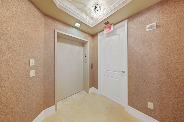 corridor with a tray ceiling, elevator, and crown molding