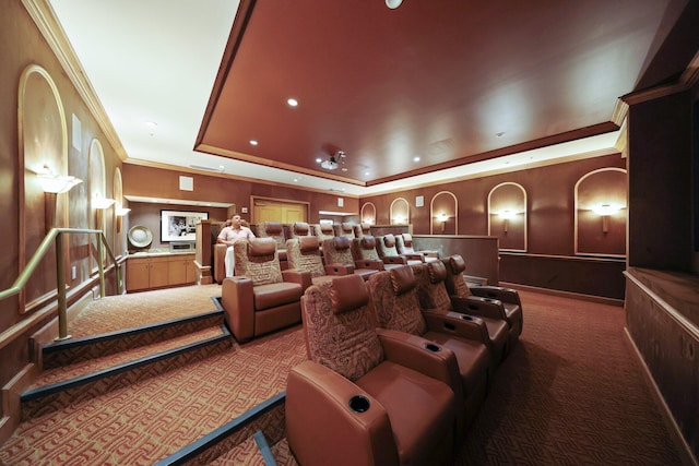 carpeted cinema room featuring a tray ceiling and crown molding