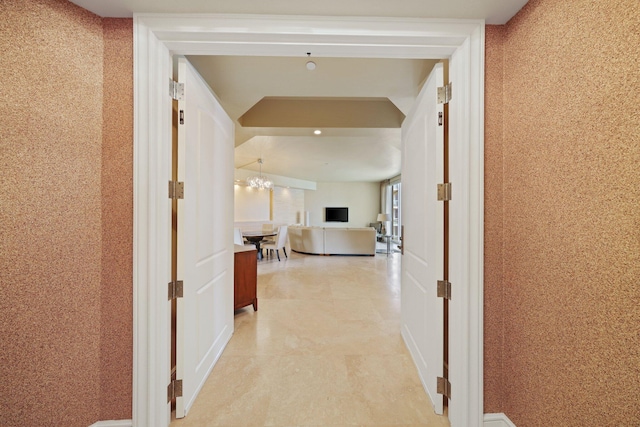 hallway with an inviting chandelier