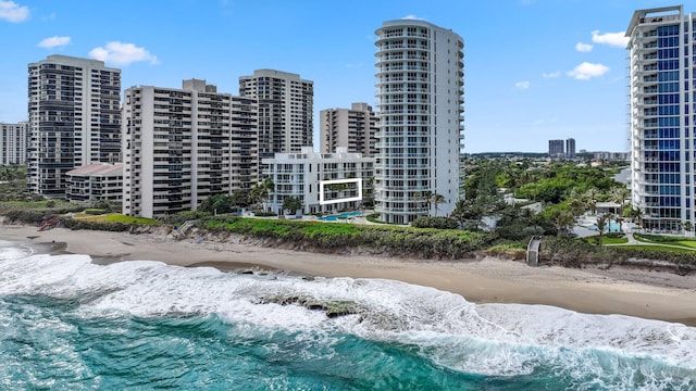 view of building exterior with a water view and a beach view