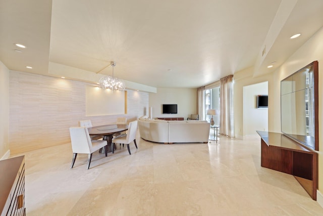 dining space with tile walls and an inviting chandelier