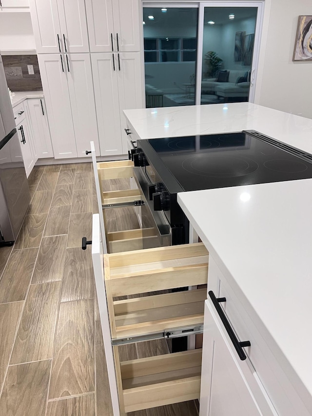 kitchen featuring white cabinetry, light countertops, and wood finish floors