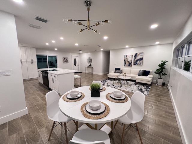 dining room with recessed lighting, visible vents, wood tiled floor, a chandelier, and baseboards