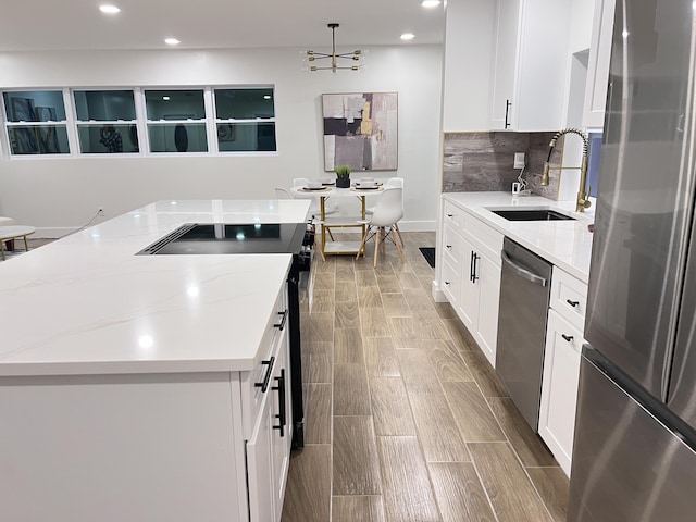 kitchen featuring stainless steel appliances, a sink, and white cabinets