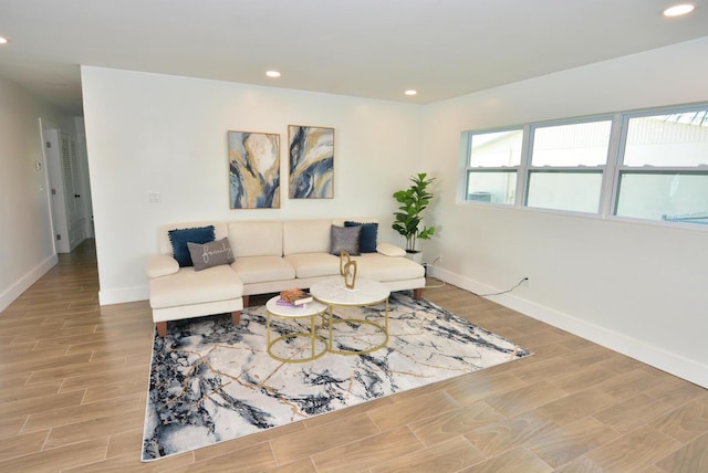 living area featuring baseboards, light wood-style flooring, and recessed lighting