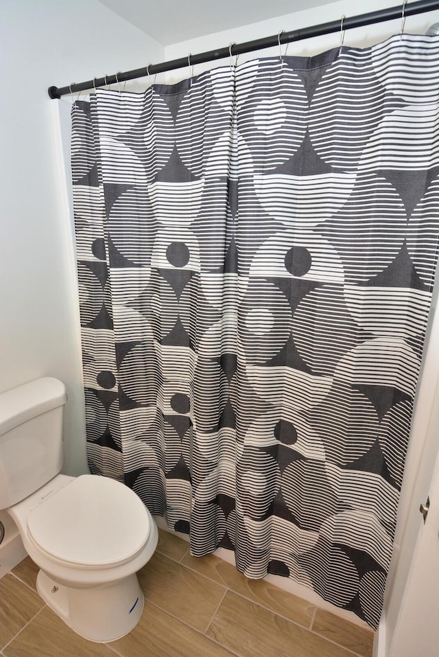 bathroom featuring a shower with shower curtain and toilet