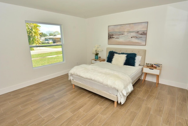 bedroom with wood finish floors and baseboards