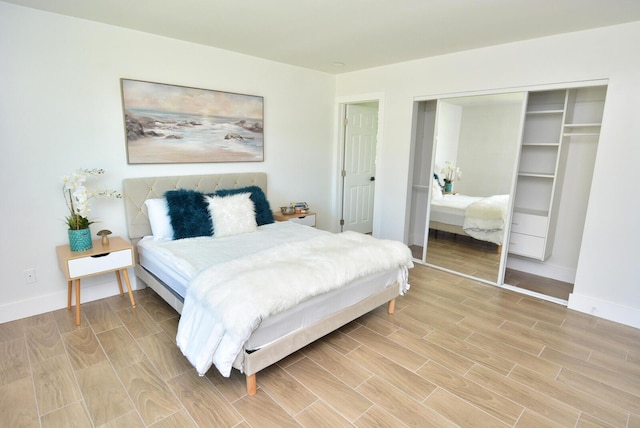 bedroom featuring wood finish floors, a closet, and baseboards