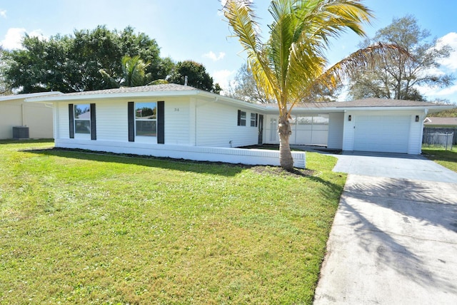 ranch-style home featuring an attached garage, driveway, a front lawn, and cooling unit