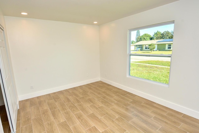 spare room with recessed lighting, light wood-style flooring, and baseboards