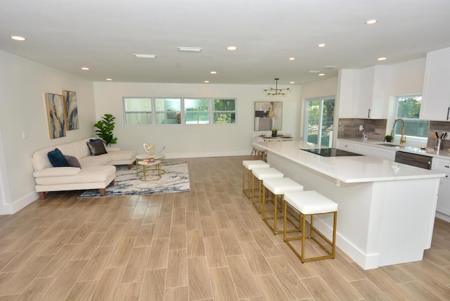 kitchen featuring a kitchen island, white cabinetry, light countertops, and open floor plan