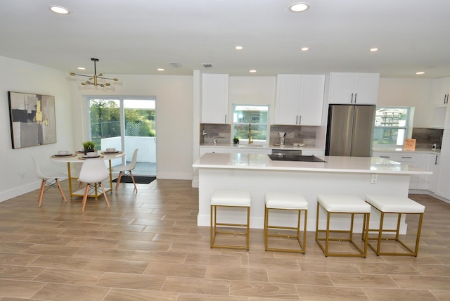 kitchen featuring freestanding refrigerator, light countertops, and a kitchen island