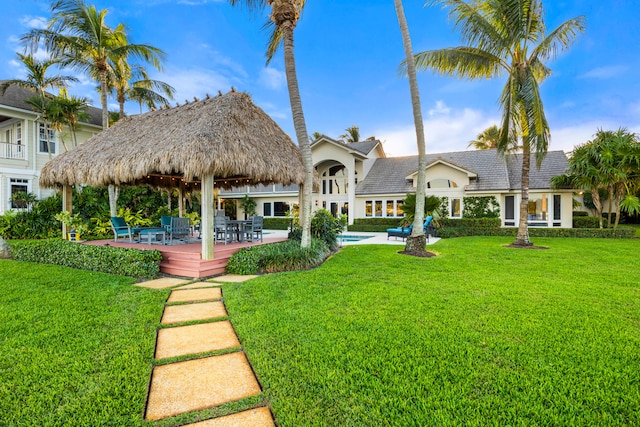 view of front of property with a gazebo, a pool side deck, and a front yard