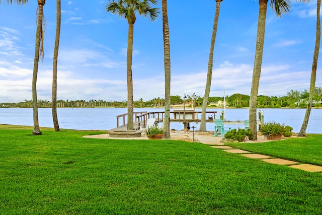 view of dock with a water view and a yard