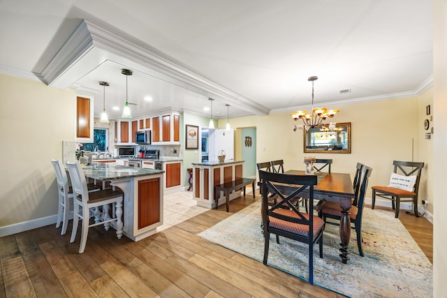 dining space featuring a chandelier, sink, light hardwood / wood-style floors, and ornamental molding