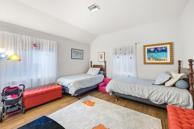 bedroom featuring wood-type flooring and vaulted ceiling