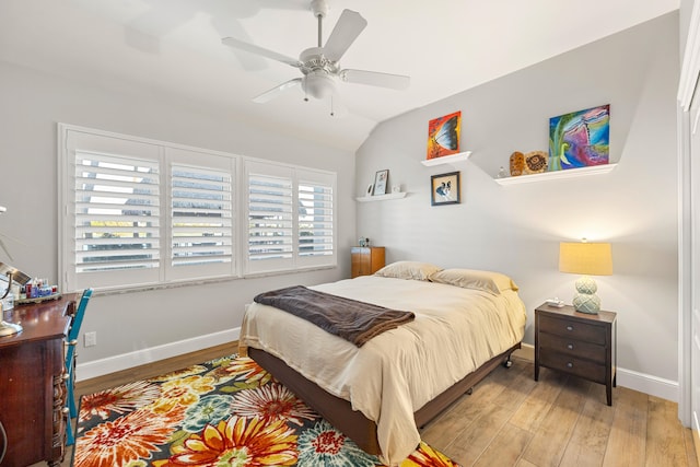 bedroom with ceiling fan, light hardwood / wood-style floors, and lofted ceiling