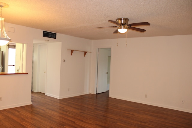 empty room with a textured ceiling, ceiling fan, and dark hardwood / wood-style floors