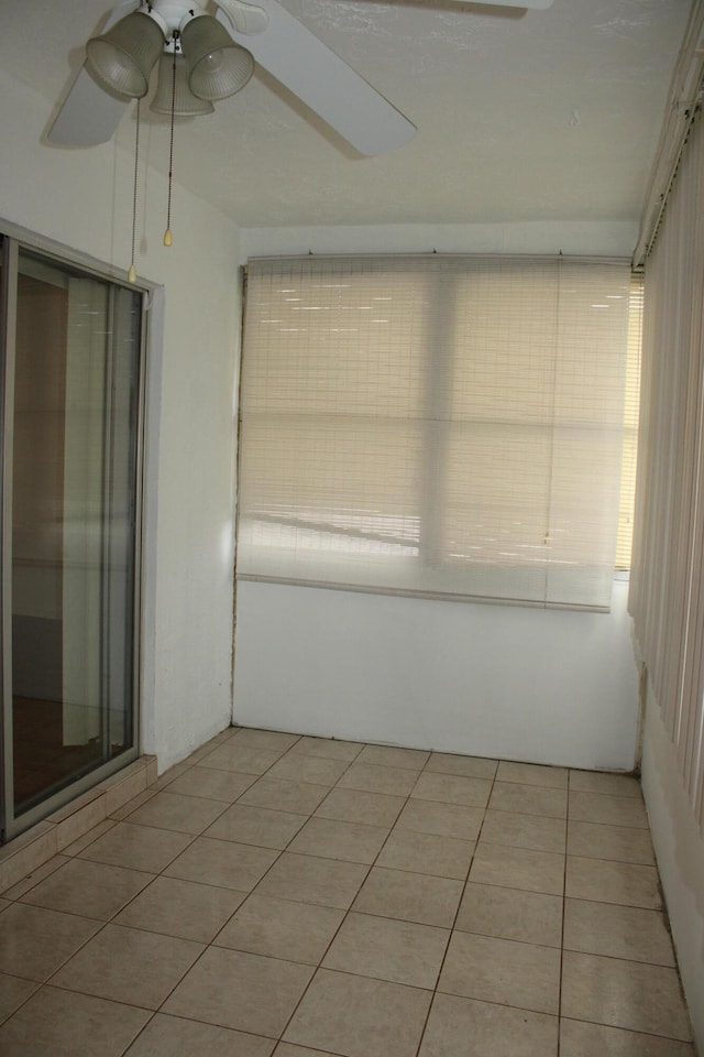 unfurnished sunroom featuring ceiling fan