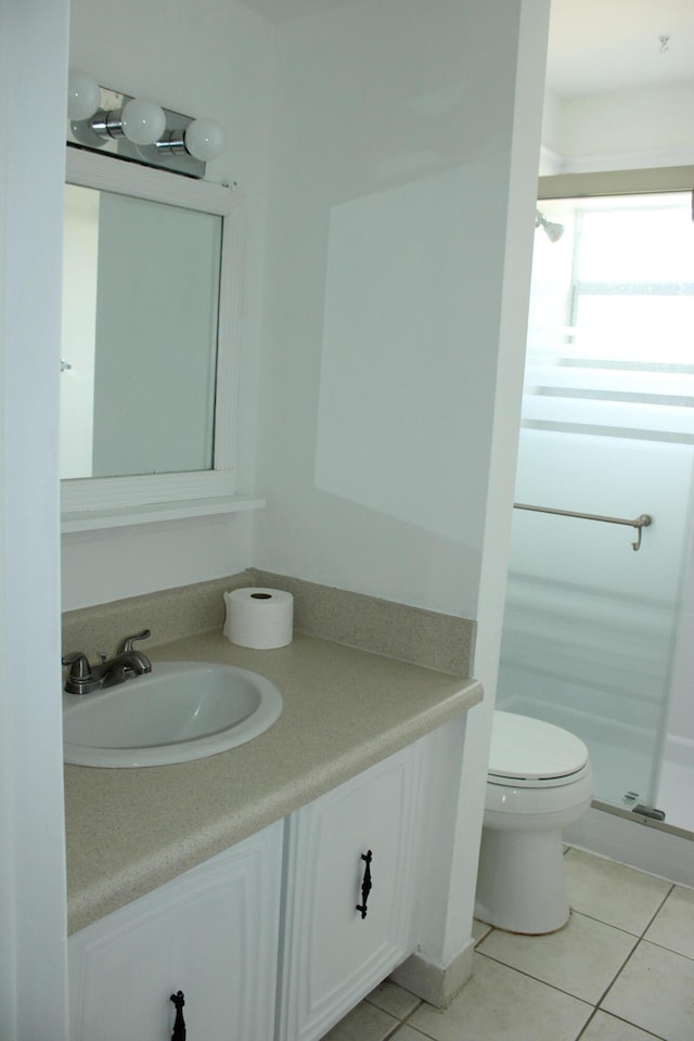 bathroom featuring tile patterned floors, vanity, toilet, and walk in shower