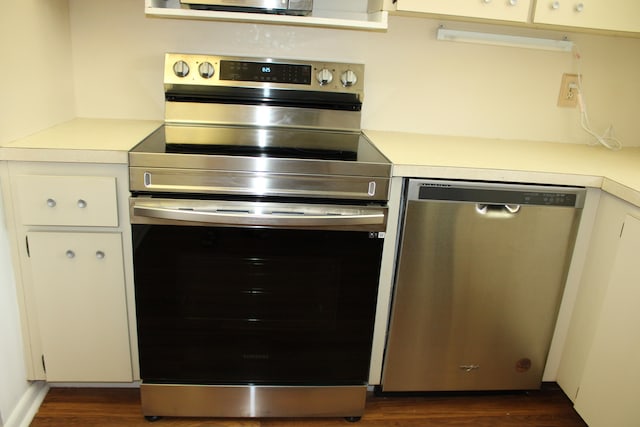 kitchen featuring white cabinetry, dark hardwood / wood-style flooring, and appliances with stainless steel finishes