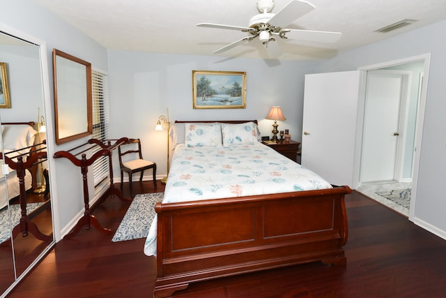 bedroom featuring ceiling fan, a closet, and dark wood-type flooring