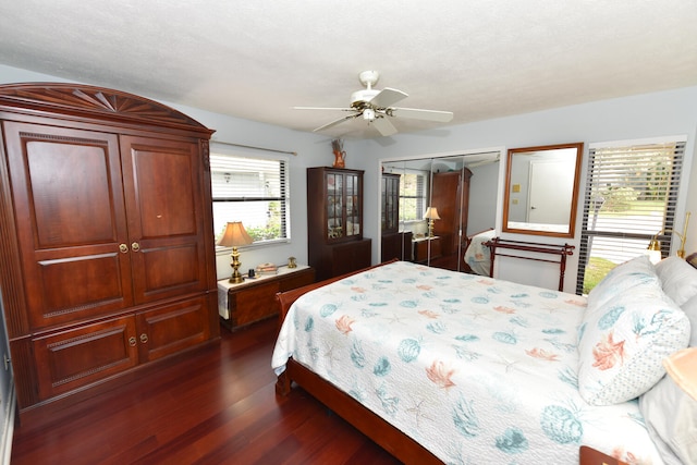 bedroom with a textured ceiling, ceiling fan, and dark hardwood / wood-style floors