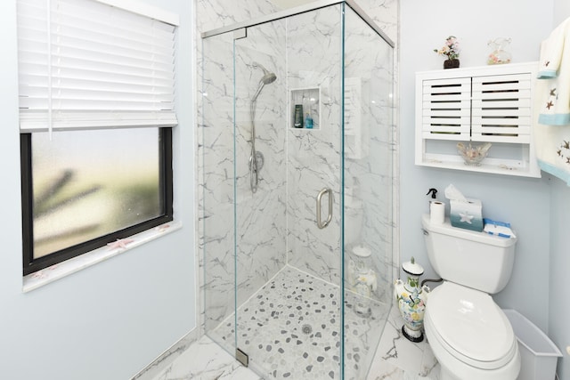 bathroom with a shower with door and toilet