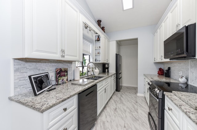 kitchen featuring black appliances, light stone countertops, white cabinetry, and sink