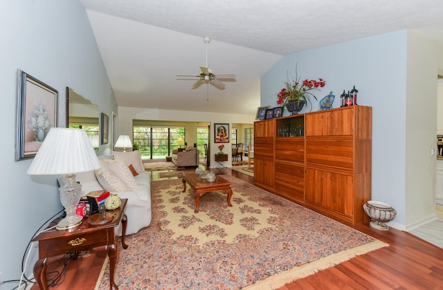 living room featuring hardwood / wood-style floors, vaulted ceiling, and ceiling fan