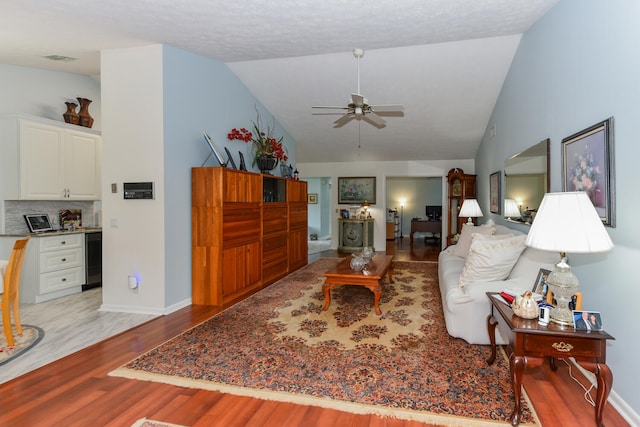 living room featuring wine cooler, light hardwood / wood-style flooring, ceiling fan, and lofted ceiling