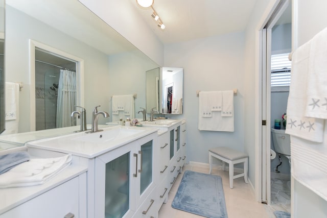 bathroom with a shower with curtain, vanity, toilet, and tile patterned floors