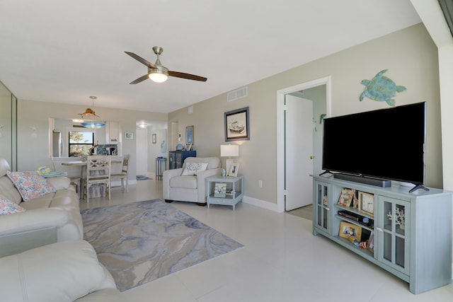 living room featuring ceiling fan with notable chandelier