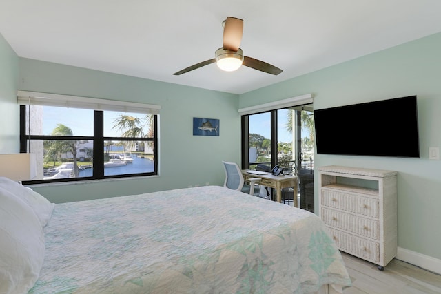 bedroom with multiple windows, ceiling fan, and light hardwood / wood-style flooring