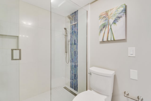 bathroom featuring toilet and tiled shower