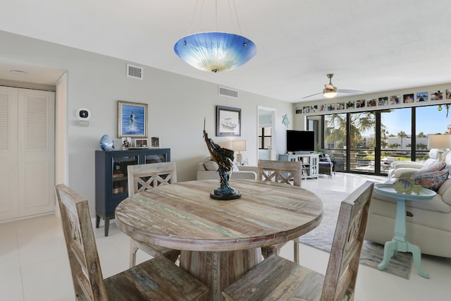 dining space with ceiling fan and light tile patterned flooring