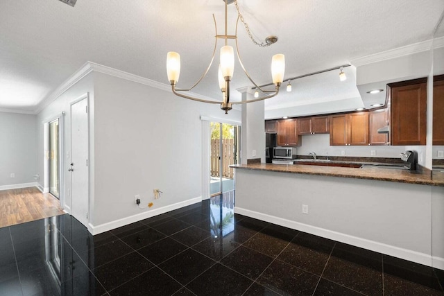 kitchen featuring an inviting chandelier, ornamental molding, a textured ceiling, decorative light fixtures, and range