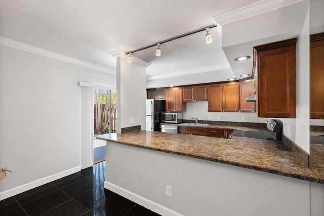 kitchen featuring kitchen peninsula, appliances with stainless steel finishes, track lighting, ornamental molding, and a textured ceiling