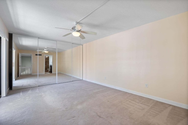 unfurnished bedroom with carpet, a closet, and ceiling fan