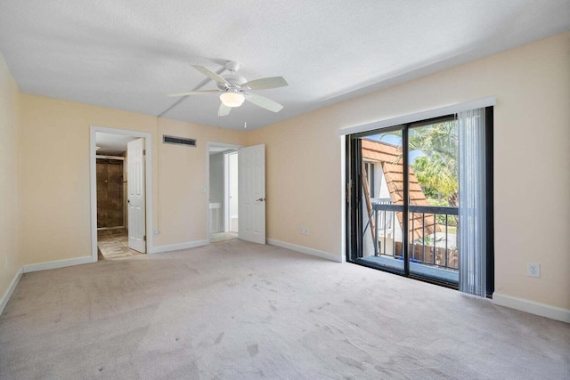 unfurnished bedroom featuring access to exterior, a textured ceiling, light colored carpet, and ceiling fan