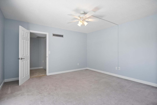 carpeted spare room with ceiling fan