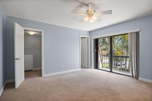 unfurnished bedroom with access to outside, ceiling fan, a textured ceiling, light colored carpet, and a closet