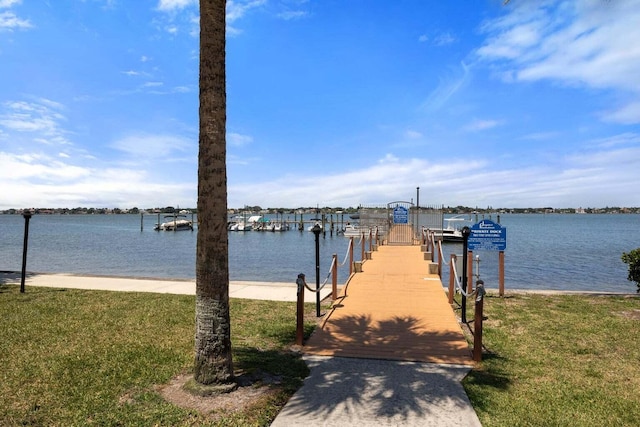 view of dock featuring a lawn and a water view