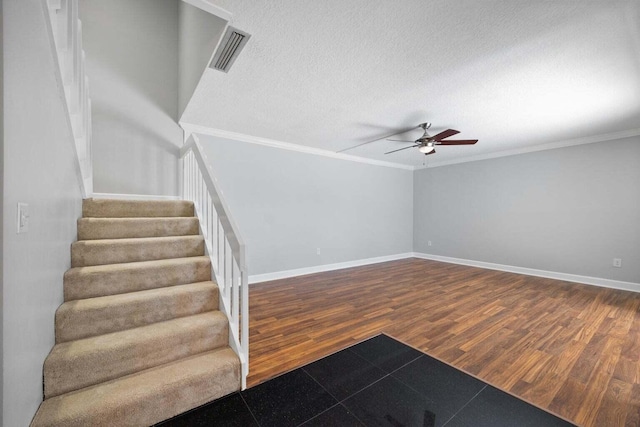 interior space featuring hardwood / wood-style floors, ceiling fan, crown molding, and a textured ceiling