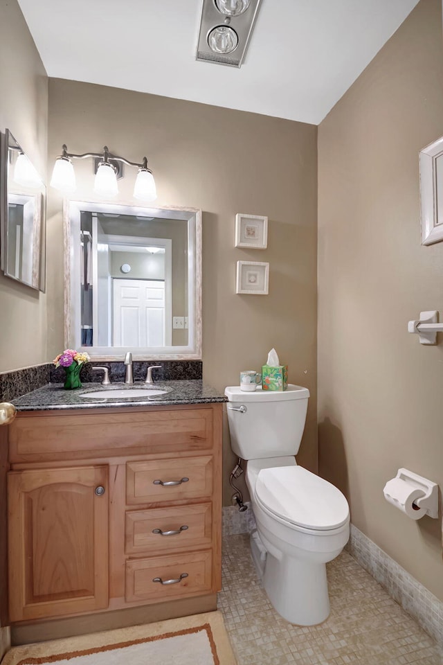 bathroom featuring tile patterned flooring, vanity, and toilet