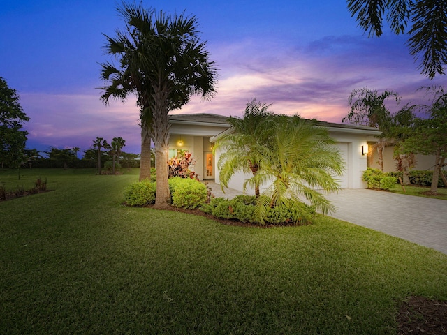 view of front of home featuring a lawn and a garage