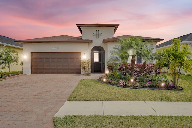 mediterranean / spanish house with a lawn and a garage