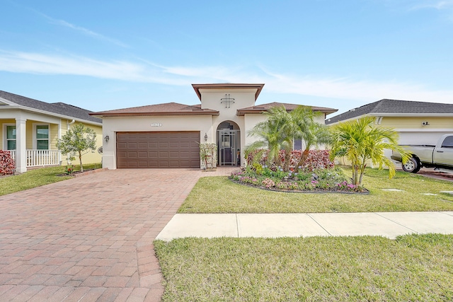 mediterranean / spanish house featuring a garage and a front lawn